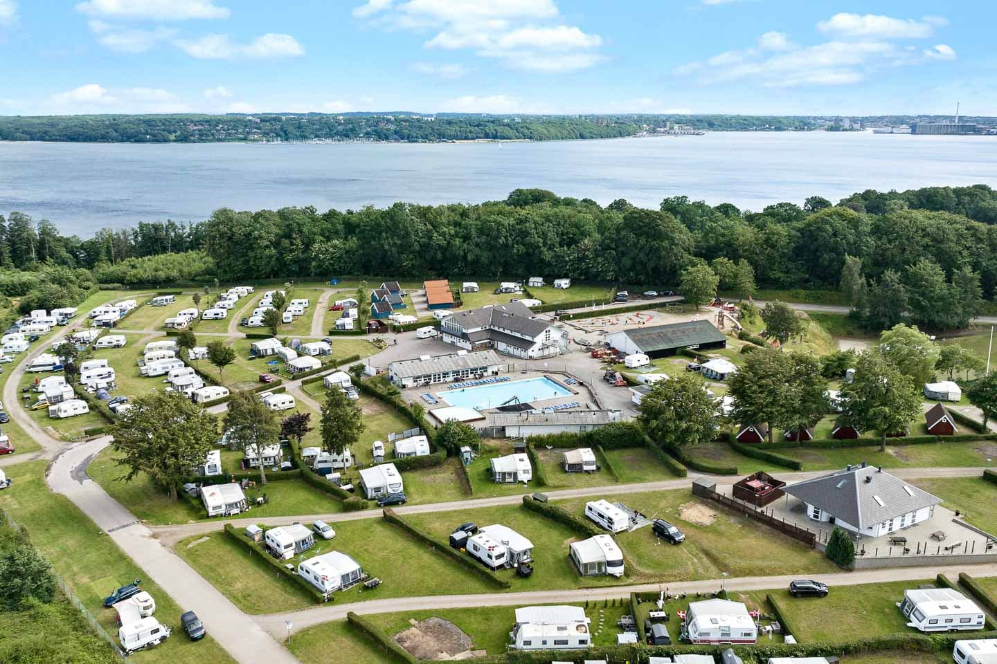 Scenic camping pitches at First Camp Frigård near Flensburg Fjord surrounded by greenery