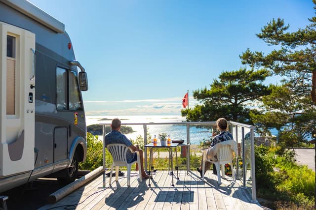 Två gäster som sitter utanför husbilen och blickar ut över Kosterhavet på City Strömstad