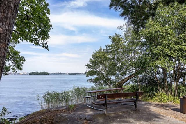 Utsikt över Mälaren och en bänk framför vattnet.