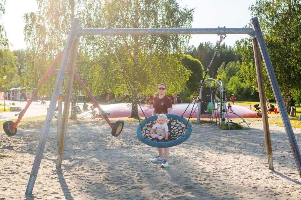 Barn som gungar på lekplatsen på Nydala Umeå camping