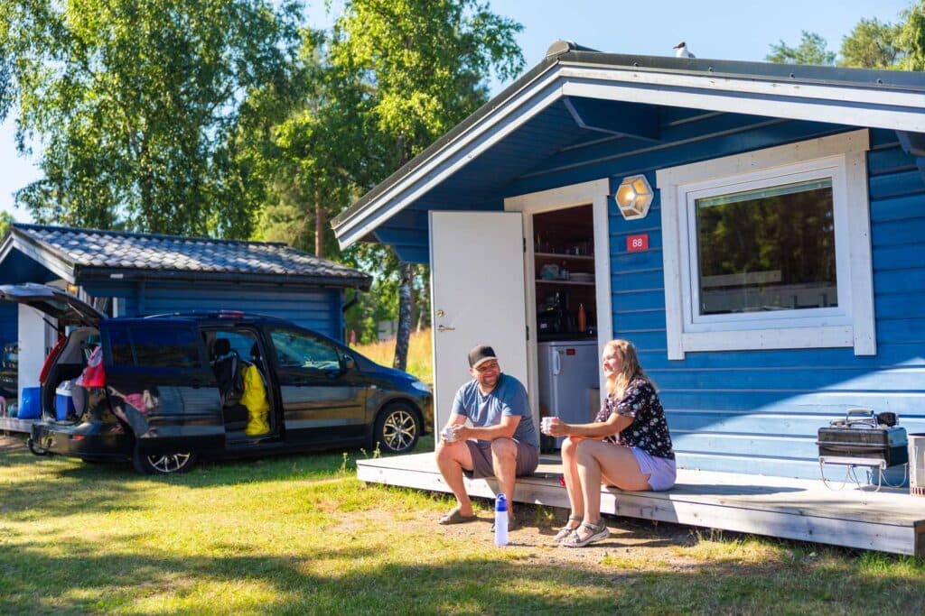 Par som sitter utanför stuga på Skara Sommarland camping